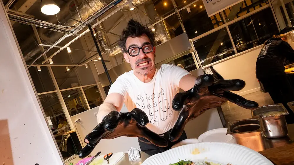 Alexandre Suergiu tend une assiette vers l'objectif, sur son stand.